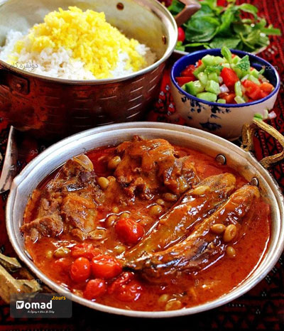 khoresht Bademjan, a Persian food, with rice and Shirazi salad served in traditional copper dishes