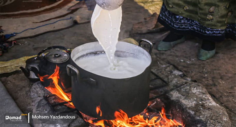 A pot of fresh goat milk on the fire