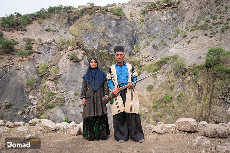 A Nomad Couple in the Zagros mountains, with a gun in the man's hands