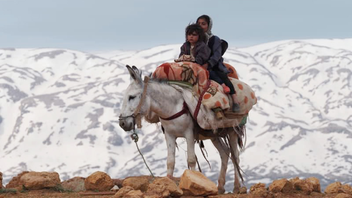 Keyno mountains on the background and two nomadic children on the donkey above the mountain